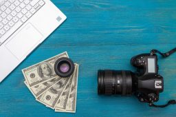 earn-money-internet-dslr-camera-dollars-laptop-blue-wooden-background-top-view_160321-1047