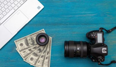 earn-money-internet-dslr-camera-dollars-laptop-blue-wooden-background-top-view_160321-1047